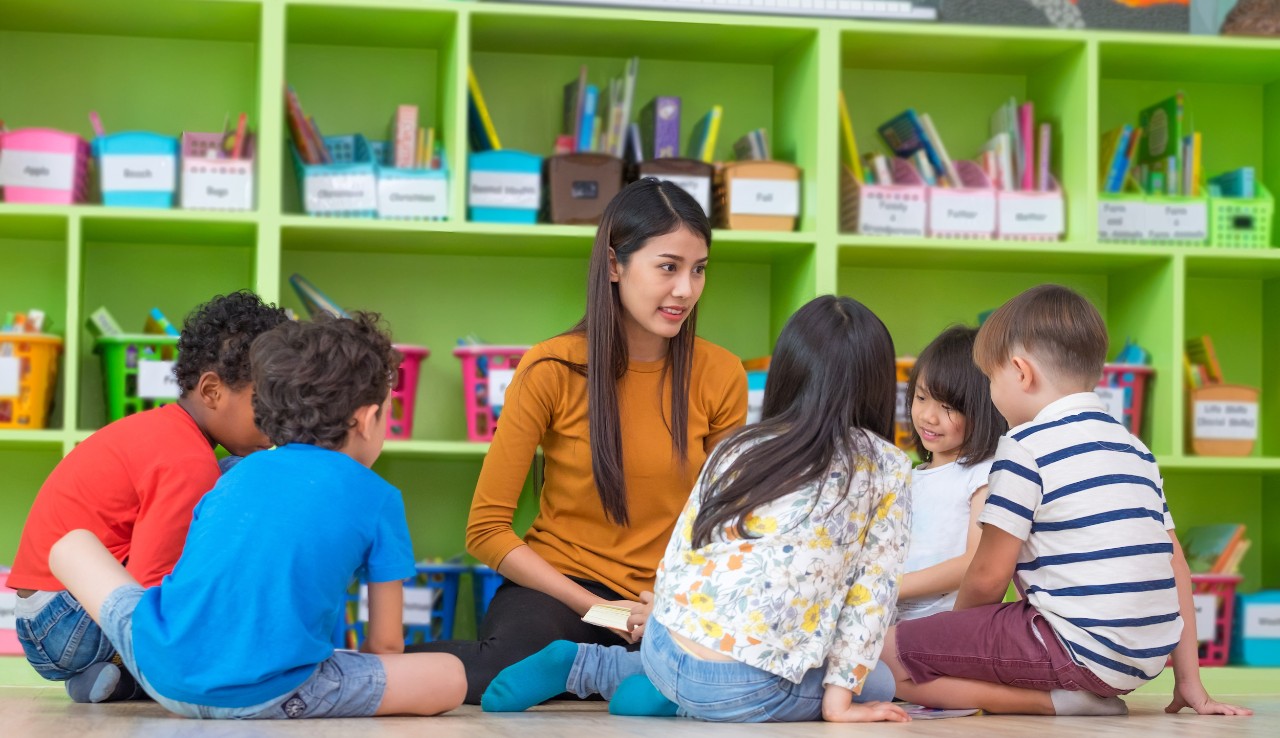 student-with-children-in-classroom student doing activity with children in classroom