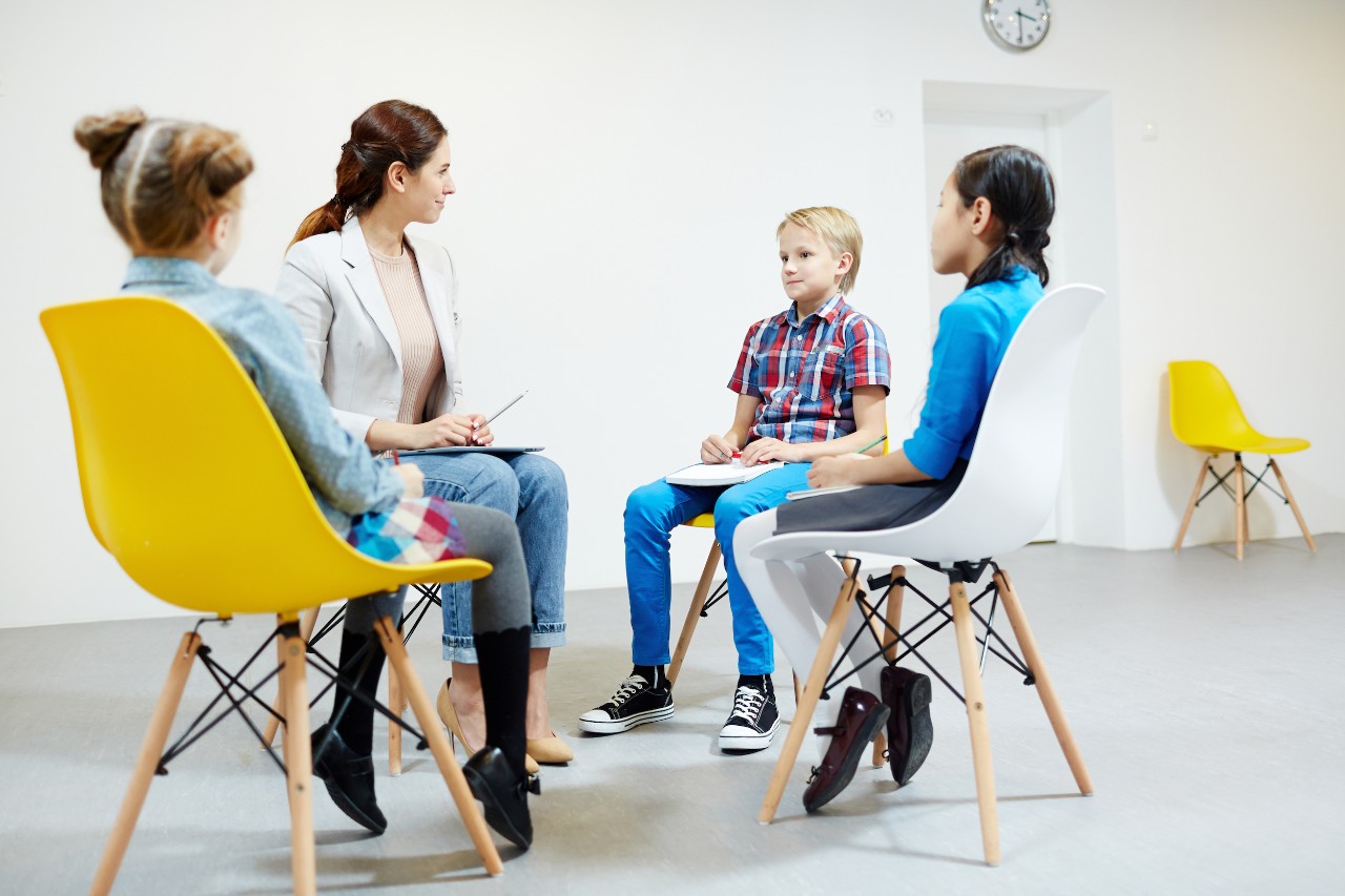 student-teaching-children student helping kids at therapy session