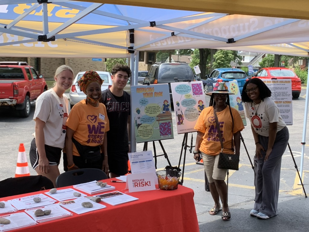 Students at a community fair with research posters 