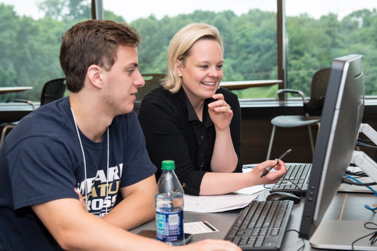 Advisor helps two students in the computer lab