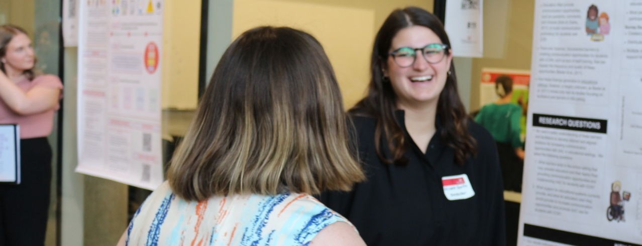 Student explains research to other student at research conference